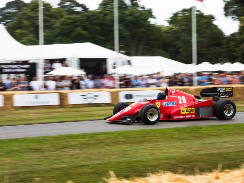 A red race car speeding on a track, showcasing its sleek design and vibrant color.